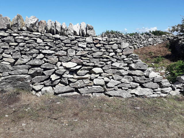 A completed section of the repaired wall with coping stones