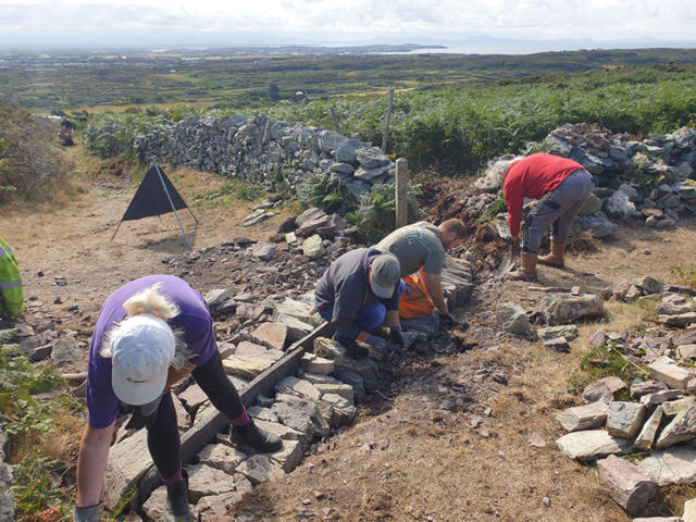 Volunteers placing stone to create a water break
