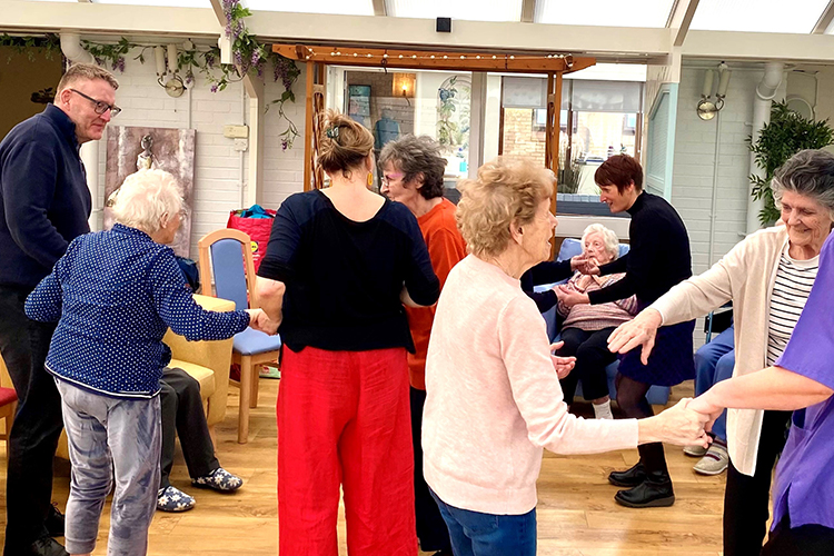 Group of people dancing and holding hands.
