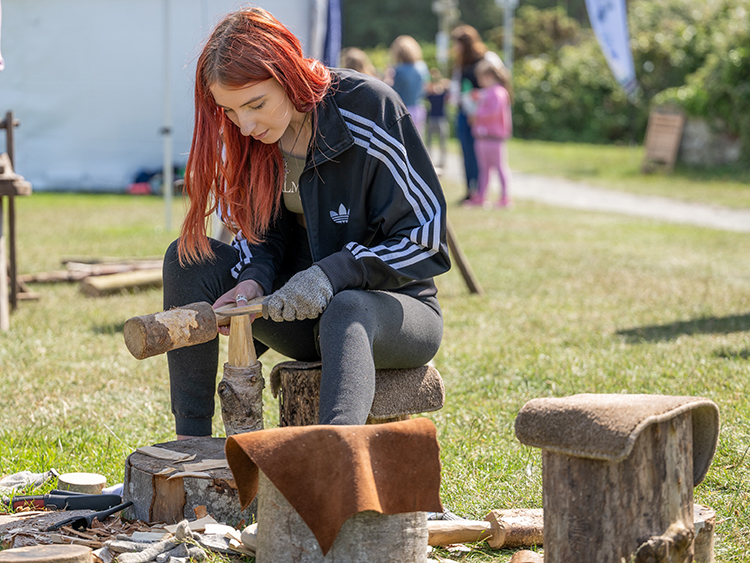 A woman carving some wood.