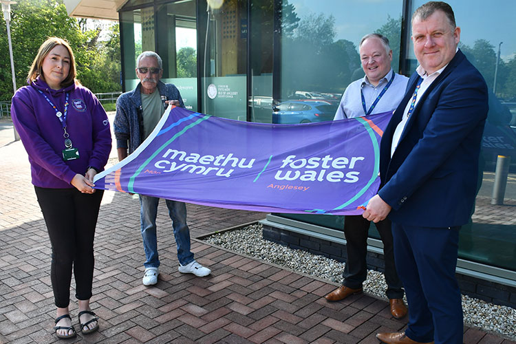 Anglesey council staff holding a foster care flag