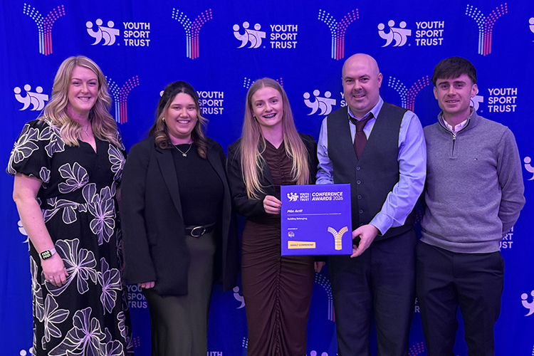 Staff from Isle of Anglesey County Council in smart clothes receiving an award